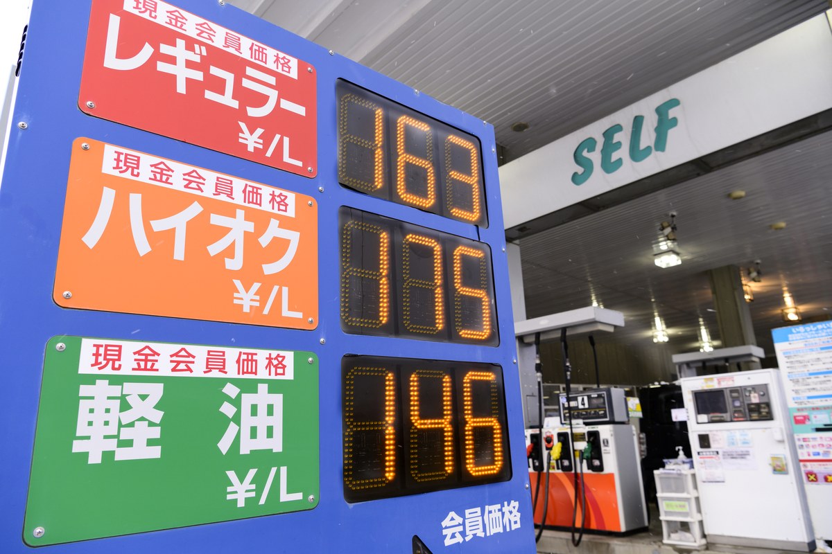 ガソリンスタンドの価格表示看板と給油の様子